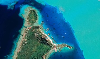 Bora Bora tatil beldesi adasının kıyı manzarası turkuaz su ve kumlu plajlardan kuş bakışı manzaralı.