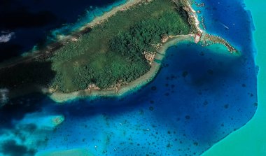 Bora Bora tatil beldesi adasının kıyı manzarası turkuaz su ve kumlu plajlardan kuş bakışı manzaralı.