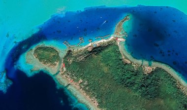 Bora Bora tatil beldesi adasının kıyı manzarası turkuaz su ve kumlu plajlardan kuş bakışı manzaralı.