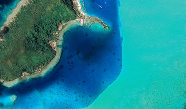 Bora Bora tatil beldesi adasının kıyı manzarası turkuaz su ve kumlu plajlardan kuş bakışı manzaralı.