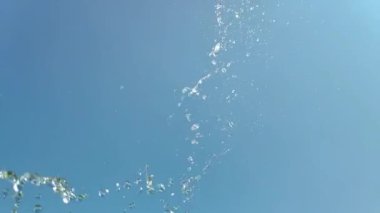 Mavi arka planda bir su sıçramasının yavaş hareketi