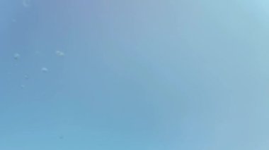 Mavi arka planda bir su sıçramasının yavaş hareketi