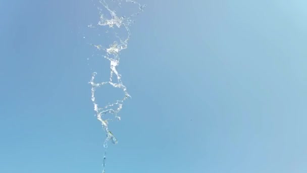 Αργή κίνηση ενός παφλασμού νερού σε μπλε φόντο του ουρανού — Αρχείο Βίντεο