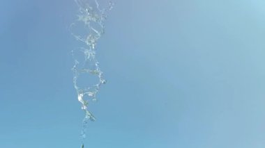 Mavi arka planda bir su sıçramasının yavaş hareketi