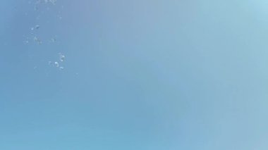 Mavi arka planda bir su sıçramasının yavaş hareketi