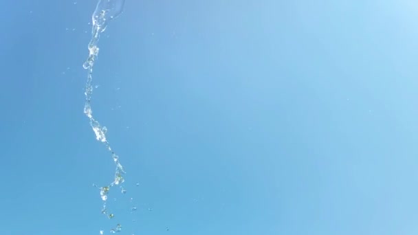 Повільний рух струменя водяного бризу на фоні блакитного неба — стокове відео