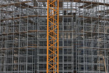 Binanın önünde iskeleli bir vinç var.