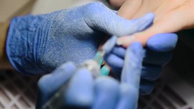 Manikür. Manikür makinesi ve kesiciyle jöle cilası çıkarıyorum. Güzellik salonu