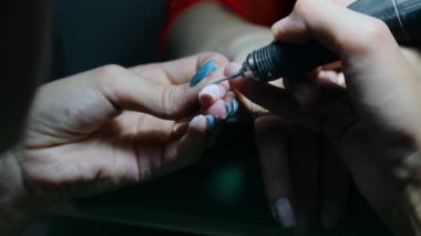 Manikür. Manikür makinesi ve kesiciyle jöle cilası çıkarıyorum. Güzellik salonu