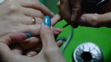 Manikür. Özel manikür araçları yardımıyla tırnaklara jel cilası sürüyorum.