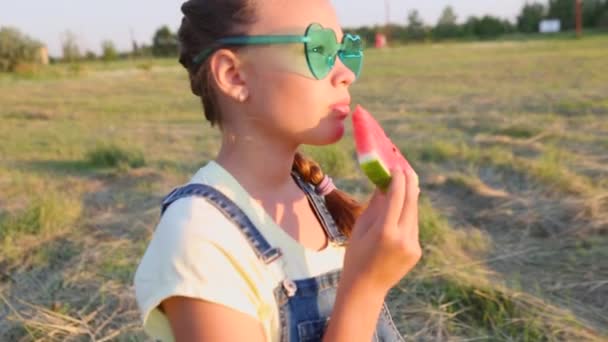 Ένα Κορίτσι Τρώει Ένα Νόστιμο Καρπούζι Στο Πάρκο Ηλιοβασίλεμα — Αρχείο Βίντεο