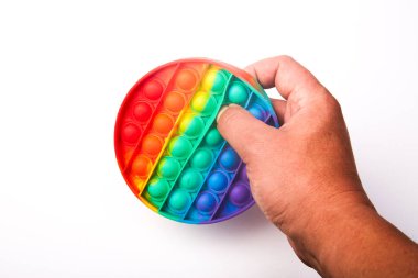 Multi-colored children's toy Pop it in the hands on a white background
