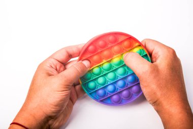 Multi-colored children's toy Pop it in the hands on a white background