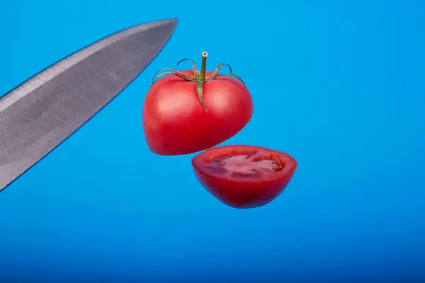 Mavi Arka Planda Keskin Bir Bıçakla Kesilmiş Olgun Bir Domates — Stok fotoğraf