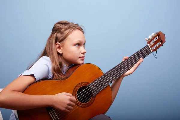 Vacker Flicka Repeterar Melodi Gitarr Med Blå Bakgrund Royaltyfria Stockbilder