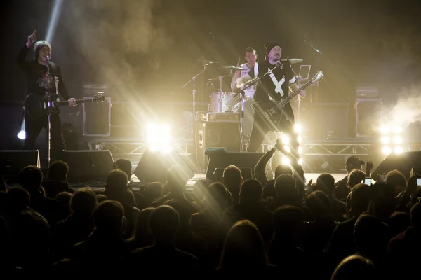 Foto van een heleboel mensen genieten van nacht perfomance van beroemde dj, grote menigte van de jeugd dansen met opgewekt handen op rockconcert, feest in dansclub, fel geel licht van fase, nachtleven — Stockfoto