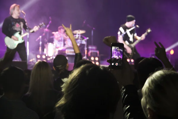 Foto van een heleboel mensen genieten van nacht perfomance van beroemde dj, grote menigte van de jeugd dansen met opgewekt handen op rockconcert, feest in dansclub, fel geel licht van fase, nachtleven — Stockfoto