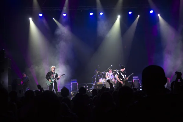 Foto van een heleboel mensen genieten van nacht perfomance van beroemde dj, grote menigte van de jeugd dansen met opgewekt handen op rockconcert, feest in dansclub, fel geel licht van fase, nachtleven — Stockfoto