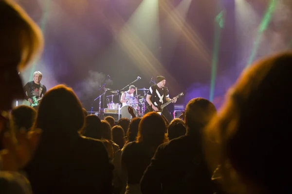 Foto van een heleboel mensen genieten van nacht perfomance van beroemde dj, grote menigte van de jeugd dansen met opgewekt handen op rockconcert, feest in dansclub, fel geel licht van fase, nachtleven — Stockfoto