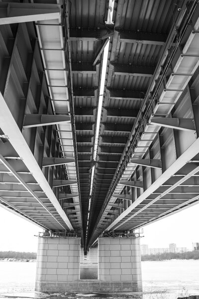 portrait view of a long bridge over blue sky and fall forest