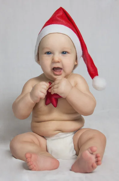 Pequeño niño lindo con sombrero de santa sobre fondo azul — Foto de Stock