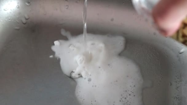 Моющие трубы на кухне с использованием бытовой химии. впитаться в канализацию — стоковое видео