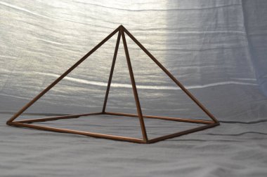 Copper pyramid.  Copper Pyramid  with lighting, white background with natural background lighting, pyramid for home use, Brazil, South America clipart
