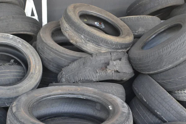 Ripped tire in a stack of tires, in front of the tire shop in a tire store in Brazil, South America , Pile of used tires in poor condition, some ripped tires