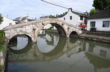 Çin, Şangay yakınlarındaki Jinze Antik Su Kasabası 'nda bir kanoyla kasaba kanallarını keşfeden bir köprü.