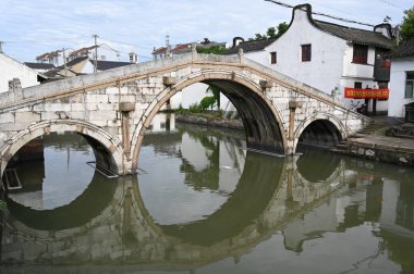 Çin, Şangay yakınlarındaki Jinze Antik Su Kasabası 'nda bir kanoyla kasaba kanallarını keşfeden bir köprü.