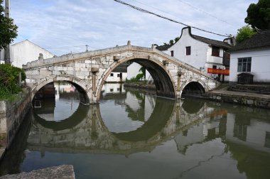 Çin, Şangay yakınlarındaki Jinze Antik Su Kasabası 'nda bir kanoyla kasaba kanallarını keşfeden bir köprü.