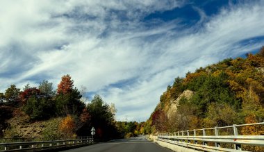 Bulgaristan 'da Balkan sıradağları boyunca araba sürmek ve sonbahar ağaçları ve doğanın güzel düşen yapraklarına hayran olmak