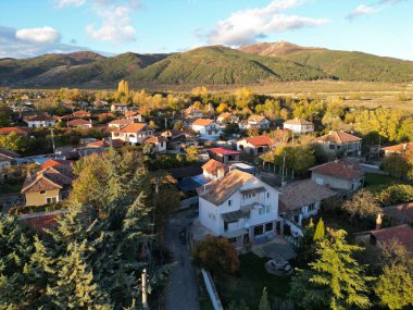 Bir İHA ile uçmak ve güneşli bir sonbahar öğleden sonrasında Bulgaristan 'ın orta kesiminde Balkan dağının eteklerinde küçük bir kasaba kaydetmek.
