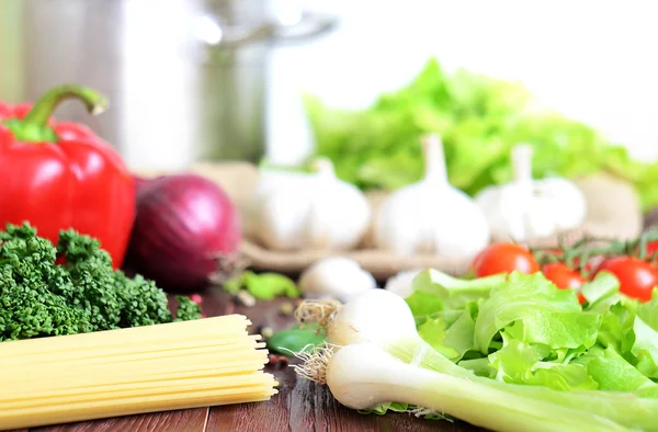 Pimienta, tomate, perejil, espaguetis y ajo sobre mesa de madera — Foto de Stock