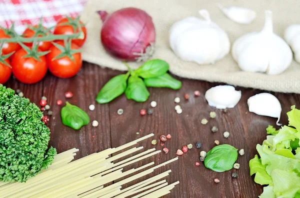 Tomates, spaghettis et ail sur table en bois — Photo