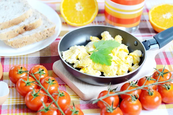 Ovos mexidos, pão torrado, sumo fresco, tomate e laranjas — Fotografia de Stock