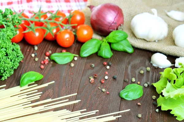 Tomates, spaghettis, oignons et ail sur table en bois — Photo