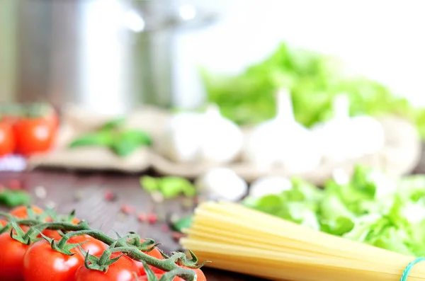 Tomaten, Spaghetti und Knoblauch auf Holztisch — Stockfoto