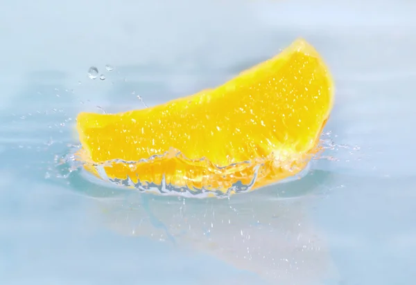 Morceau de citron frais tombant dans l'eau — Photo