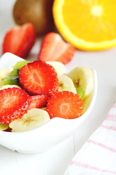Tigela com salada de frutas - pedaços de morango, laranja e kiwi — Fotografia de Stock