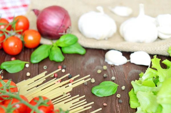 Tomates, spaghettis, oignons et ail sur table en bois — Photo