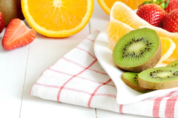 Tigela com salada de frutas - pedaços de kiwi, morango e laranjas — Fotografia de Stock