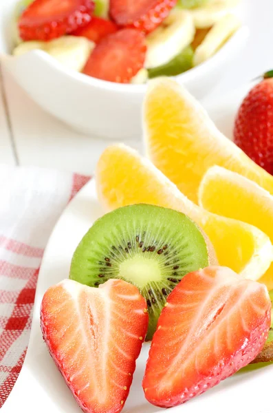 Bowl with fruit salad - pieces of strawberry, oranges, and kiwi — Stock Photo, Image