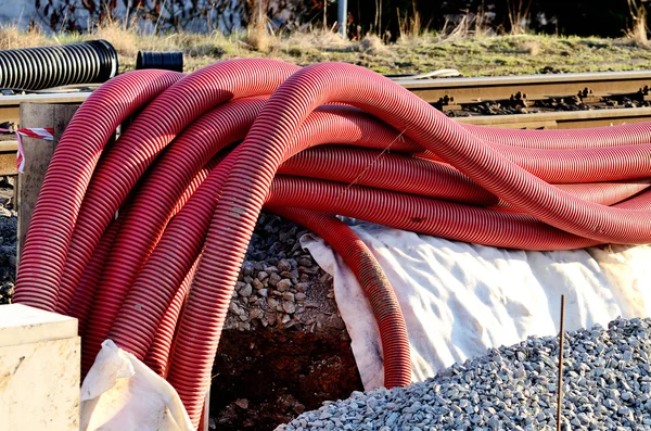 Mangueiras de plástico vermelho no canteiro de obras — Fotografia de Stock