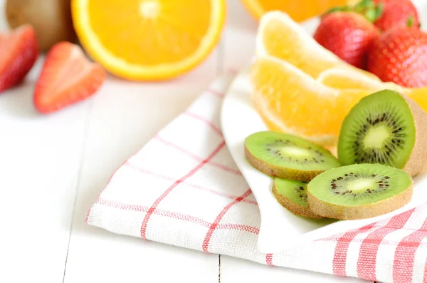 Tigela com salada de frutas - pedaços de laranja, morango e kiwi — Fotografia de Stock