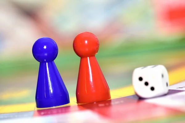 Close-up de azul, figuras de jogo vermelho e dados no jogo de tabuleiro. — Fotografia de Stock