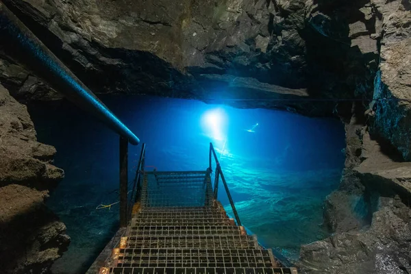 Nurkowie jaskiniowi trenują głębokie nurkowania w starym jeziorze kopalni węgla. Światło z zimnej niebieskiej wody — Zdjęcie stockowe