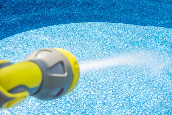 Primer plano de llenar el agua en una piscina vacía por manguera de jardín —  Fotos de Stock