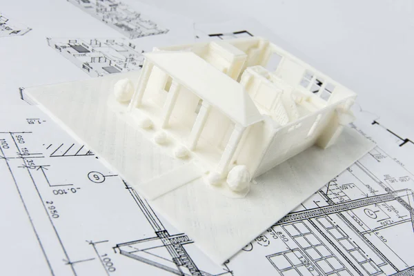 Modelo do primeiro andar de uma casa de família impressa em uma impressora 3D com filamento branco pela tecnologia FDM para uso arquitetônico. Imagem De Stock