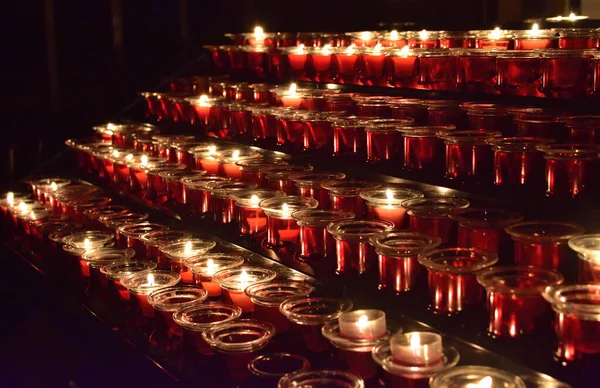 Rijen brandende kaarsen in een kerk tijdens een kerstdienst — Stockfoto